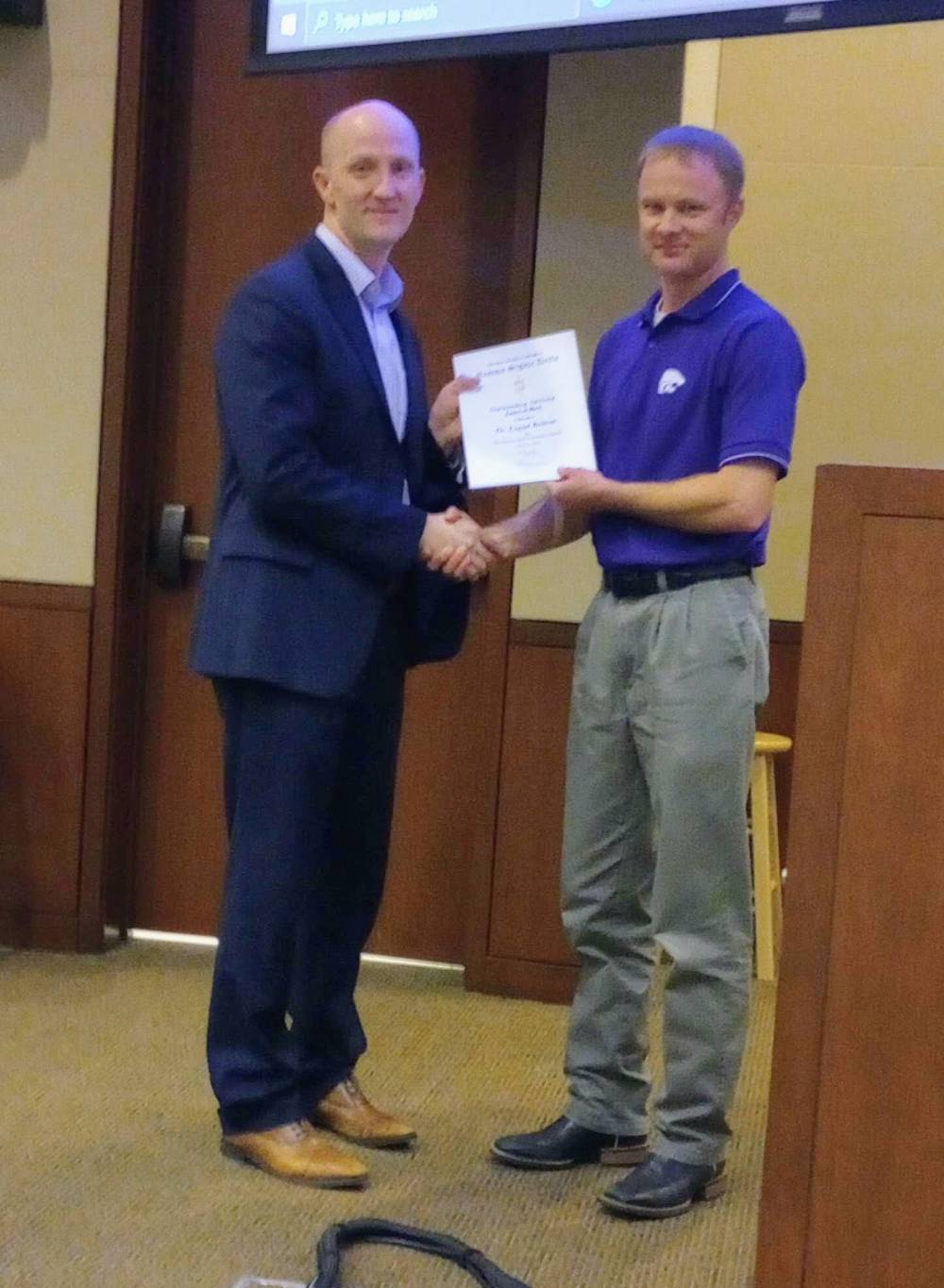 Mike Stamm presenting Outstanding Advising award to Dr. Logan Britton